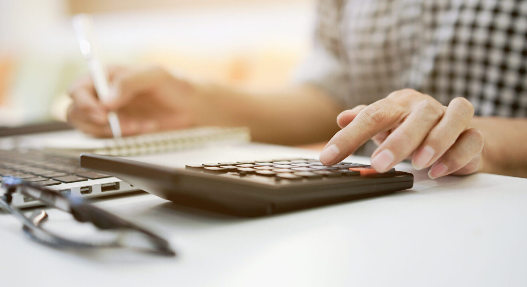 Person using calculator on desk.